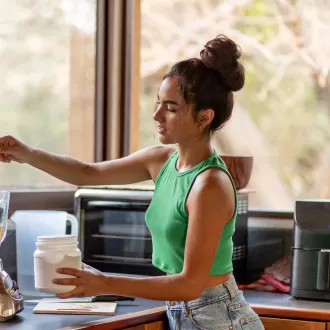 A teenage girl making a smoothie