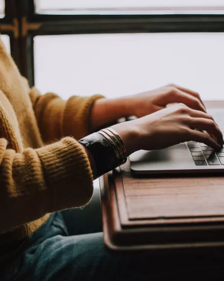 Close up of a person typing on a laptop