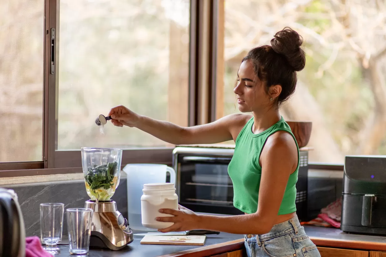 A teenage girl making a smoothie