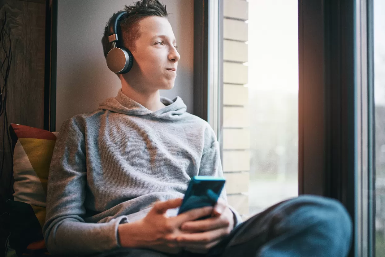 Teenage boy on smart phone looking content