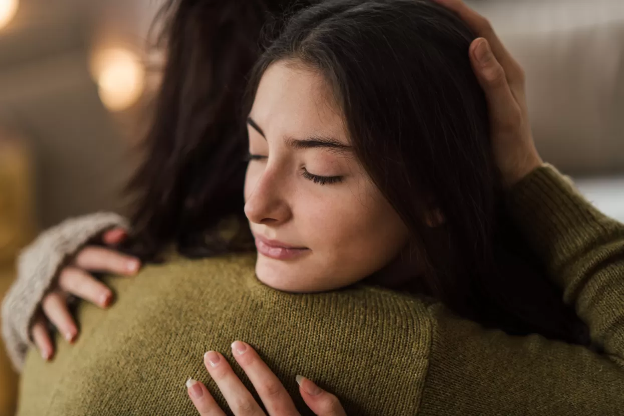 Teenage girl being consoled by an adult