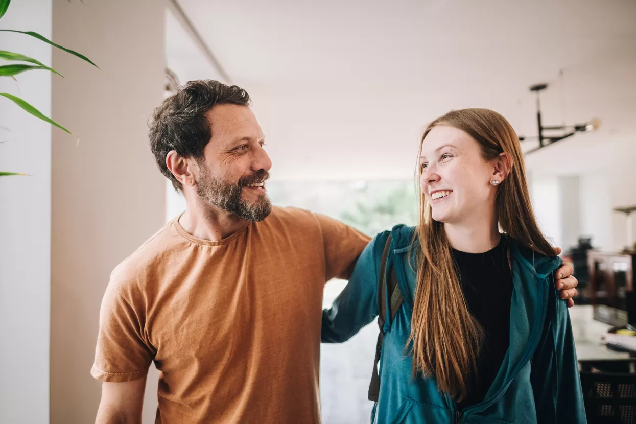 Man and teenage girl smiling at each other 