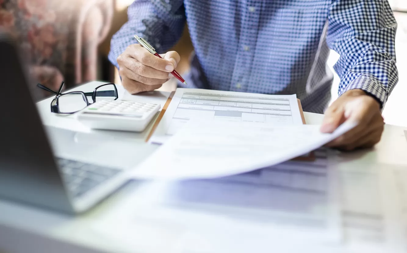 Man at a desk signing paperwork