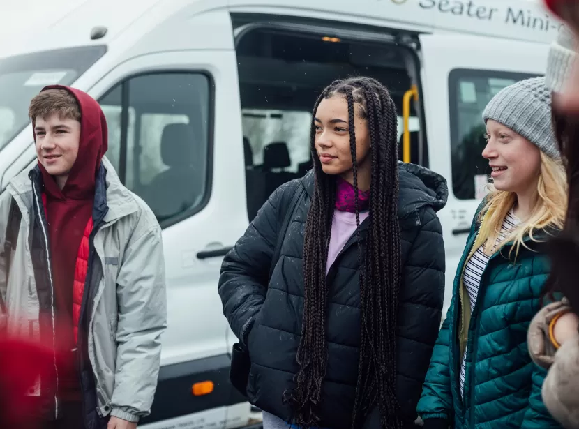 Teenagers stood by minibus ready for a day out hiking